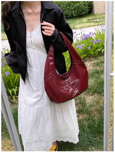 Close-up of a retro wine red hobo bag featuring stylish silver star rivet decorations