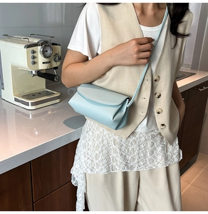 Détail du sac bandoulière en cuir grainé bleu clair montrant sa texture et ses plis