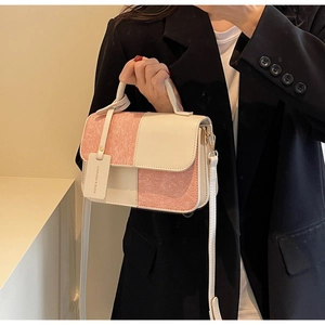 Detail of pink tweed and white leather contrast stitching on woman's crossbody bag