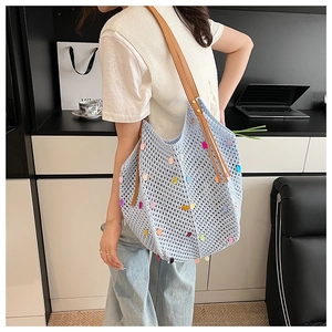 Détail du sac cabas en tricot bleu avec sequins colorés et anses en cuir marron