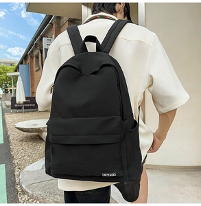 Side view of a minimalist black campus backpack with side water bottle pocket and brand tag