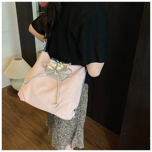 Close-up of pink tote bag with silver leather flap and stylish ribbon bow detail