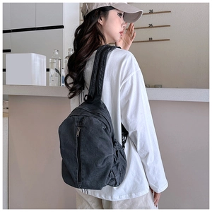 Détail du sac bandoulière en denim gris montrant la sangle et le cordon de serrage