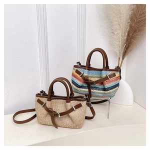 Detail of hand-woven straw tote bags with brown leather trim and adjustable straps