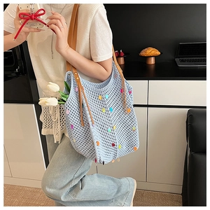 Détail du sac cabas au crochet bleu clair avec sequins colorés et anses en cuir