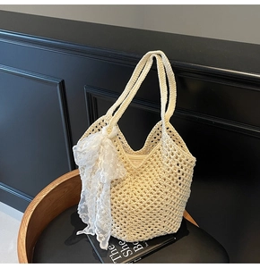 Détail d'un sac cabas au crochet avec texture ajourée et nœud en dentelle blanc