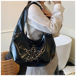 Close-up of black glossy punk underarm bag with silver star rivet patterns