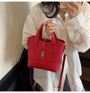 Close-up of a red litchi-grain leather bucket bag with silver clasp and top handles