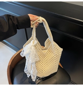 Gros plan du sac fourre-tout beige tissé avec un nœud décoratif en dentelle blanche élégant