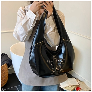 Detail of silver rivets star pattern on black glossy leather punk hobo shoulder bag