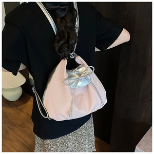 Detailed view of pink satin backpack with silver bow decoration and drawstring closure