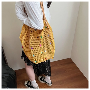 Detail of yellow knit tote bag featuring colorful sequins and premium brown leather straps