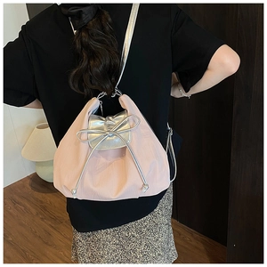 Pink pleated tote bag with silver bow detail and metallic straps shown on a model