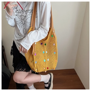 Detail of yellow knit tote bag featuring colorful sequins and brown leather straps