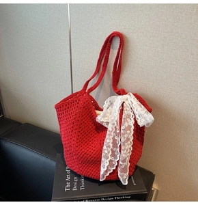 Détail d'un sac cabas en maille rouge avec un grand nœud en dentelle blanche brodée