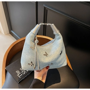 Close-up of light blue glitter Hobo bag with silver metal butterfly and knot handle