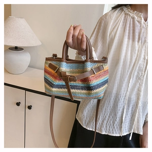 Detailed macro shot of the colorful hand-woven texture and brown leather strap on the bag