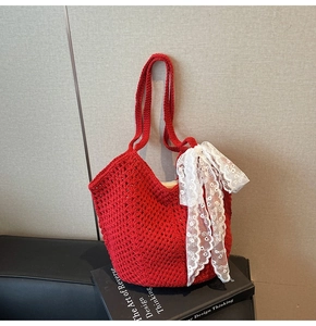 Détail du sac cabas en crochet rouge avec un grand nœud en dentelle blanche