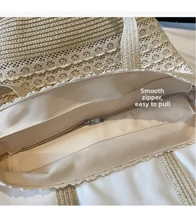 Détail de la fermeture éclair en métal et de la dentelle sur le sac cabas en paille