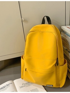 Bright yellow minimalist school backpack with multiple pockets and durable fabric
