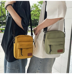 Outdoor street shot of ginger and sage green crossbody bags with adjustable straps