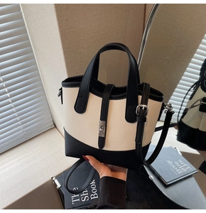 Detail of lychee pattern leather bag with metallic twist lock and adjustable strap