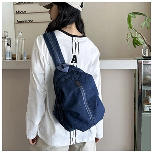 Détail du sac à bandoulière en denim bleu avec fermeture éclair et sangle ajustable