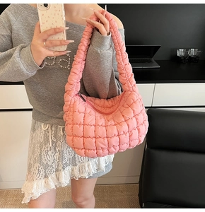 Primer plano del bolso nube acolchado rosa con asa fruncida y textura de tela suave