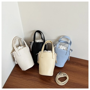 Detail of four colorful bucket bags with lychee grain texture and drawstring lining