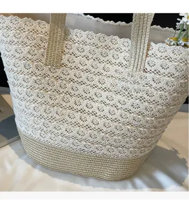 Gros plan détaillé du sac cabas tissé avec dentelle crème et base en paille naturelle