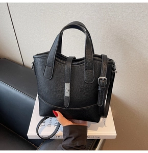 Close-up of black lychee-grain leather tote bag with silver hardware and adjustable strap