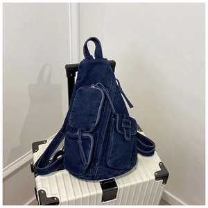 Detailansicht der dunkelblauen Denim-Umhängetasche mit Multi-Taschen-Textur auf Koffer