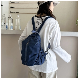 Vue latérale du sac à dos en denim bleu foncé avec bretelles réglables et poches latérales