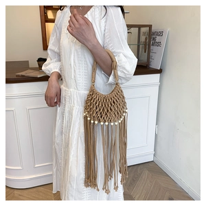 Detail view of handmade bohemian tassel woven bag featuring intricate mesh and white beads