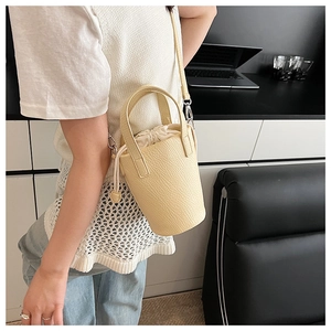 Detail view of cream lychee texture bucket bag with drawstring liner and shoulder strap