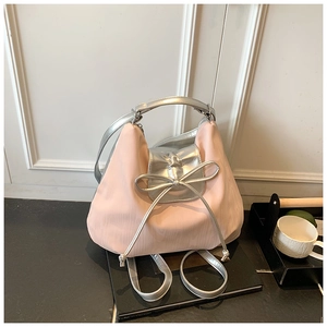 Detail of pink nylon backpack with large silver bow and metallic finish textures