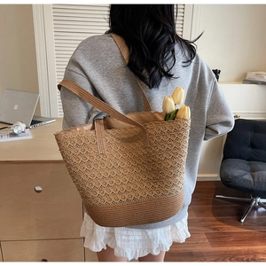 Détail d'un grand sac cabas en paille tressée avec motifs dentelle et un intérieur spacieux