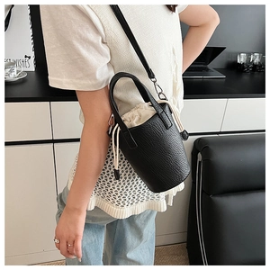 Detail view of black lychee grain bucket bag with white drawstring lining and leather texture