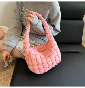 Detail of pink quilted puffy cloud bag with soft textured hobo design on leather seat
