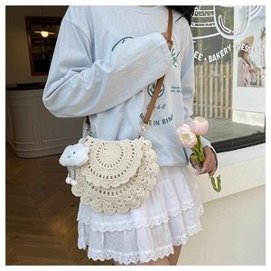 Detail of cream handmade crochet bag with wavy edges and cute cloud charm accessory