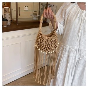 Detail view of handmade bohemian woven bag with stylish long tassels and pearl beads