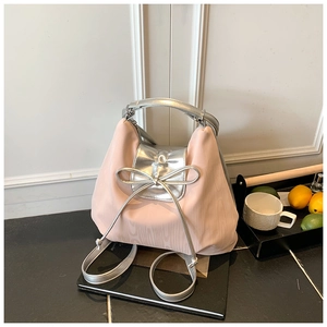 Detail of a pink and silver tote bag featuring a metallic bow and water ripple texture