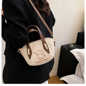 Detail of cream and brown crossbody bag with puppy print and adjustable leather strap