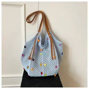 Detail of light blue crochet tote bag with colorful sequins and brown leather strap