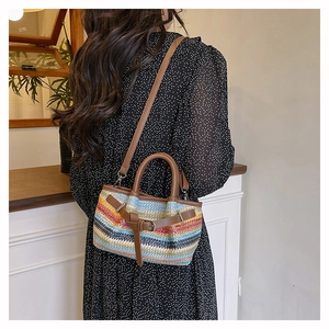Close-up of colorful striped woven beach tote with brown leather handles and strap