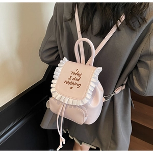 Pink PU leather mini backpack with ruffle trim and heart embroidery on grey blazer