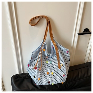 Détail du sac cabas ajouré bleu clair avec sequins colorés et bandoulière en cuir brun