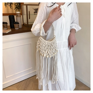Detail of white bohemian woven bag featuring handmade macrame knots and wooden beads