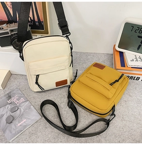 Close-up of minimalist canvas crossbody phone bags in beige and mustard yellow colors
