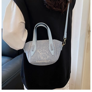 Detail of light blue glitter crossbody bag with dog print and golden metal buckles